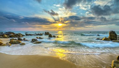 Şafak ile sahilde birçok güzel şekiller oluşturmak için beyaz kum çizgiler dalgalar ipek gibi güzel plajları üzerinde birçok kayalar vardır,