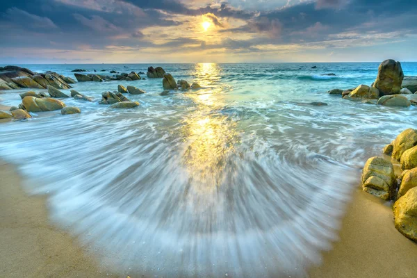 Şafak ile sahilde birçok güzel şekiller oluşturmak için beyaz kum çizgiler dalgalar ipek gibi güzel plajları üzerinde birçok kayalar vardır,