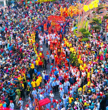Binh Duong, Vietnam - 2 Mart 2018: Festival fener genç adam heykel Tanrıçalar taşıyan ve tütsü geçidi Caddesi üzerinde ziyaretçi çeken, bu Binh Duong, Vietnam için geleneksel Çin Festivali.
