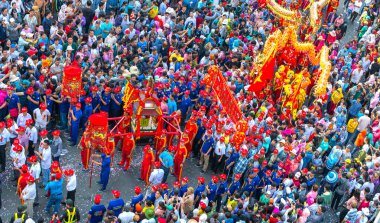 Binh Duong, Vietnam - 2 Mart 2018: Festival fener genç adam heykel Tanrıçalar taşıyan ve tütsü geçidi Caddesi üzerinde ziyaretçi çeken, bu Binh Duong, Vietnam için geleneksel Çin Festivali.