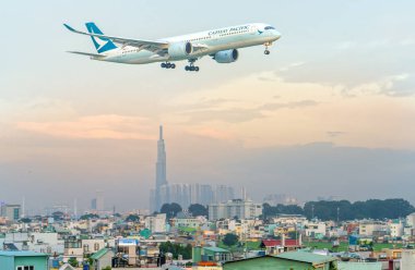 Ho Chi Minh City, Vietnam - 31 Temmuz 2018: Cathay pacific airbus a350-900 sinek üzerinde Tan Son Nhat Uluslararası Havaalanı Ho Chi Minh City, Vietnam için açılış hazırlamak için gökdelenler ile kentsel alanlarda