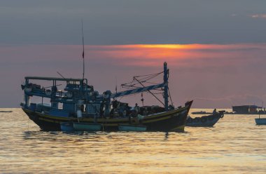 MUI Ne, Vietnam - 28 Eylül 2018: Şafakta deniz manzaralı otelde gündoğumu ufuk, deniz balığı Ticaret için MUI Ne, Vietnam kıyı balıkçı köyü aile desteklemek için Tekne taşıma balıkçılar