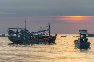 MUI Ne, Vietnam - 28 Eylül 2018: Şafakta deniz manzaralı otelde gündoğumu ufuk, deniz balığı Ticaret için MUI Ne, Vietnam kıyı balıkçı köyü aile desteklemek için Tekne taşıma balıkçılar