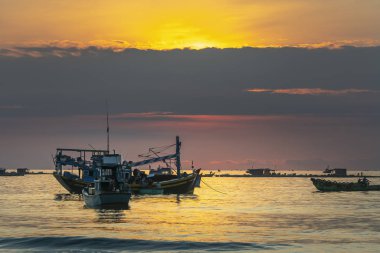 MUI Ne, Vietnam - 28 Eylül 2018: Şafakta deniz manzaralı otelde gündoğumu ufuk, deniz balığı Ticaret için MUI Ne, Vietnam kıyı balıkçı köyü aile desteklemek için Tekne taşıma balıkçılar
