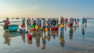 MUI Ne, Vietnam - 28 Eylül 2018: Sepet balık satış içinde balık pazarı oturum denizler sahne kişi toplandı yorucu kürek balıkçılar balık kıyıya balıkçı köyü MUI Ne, Vietnam getirdi