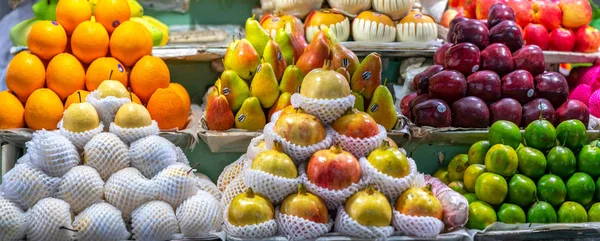 Fruit shops in the market with all kinds like: tangerines. pomegranate, orange, apple, pear, grape, mango, dragon fruit, lychee ... all Arranged on shelves look attractive and eye-catching.