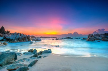 Güneş ışınları gökyüzündeki mor ve yeni gün hoş geldiniz yumuşak büyük kıyıda alıştırma dalgalar altında olarak sahilde güzel gündoğumu