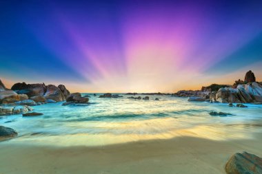 Güneş ışınları gökyüzündeki mor ve yeni gün hoş geldiniz yumuşak büyük kıyıda alıştırma dalgalar altında olarak sahilde güzel gündoğumu