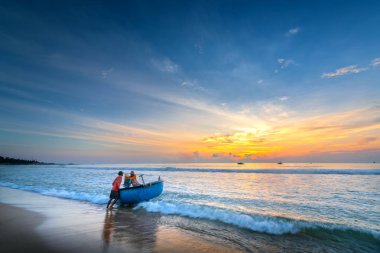 Phan Thiet, Vietnam - 30 Eylül 2018: Balıkçılar kümesi sepet tekne ile otelde aileleri içinde balıkçı köyü, Phan Thiet, Vietnam beslenme balıkçılık kadar güneş oldu sabah yola çıktı