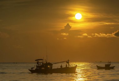 Phan Thiet, Vietnam - 30 Eylül 2018: Deniz manzaralı otelde gündoğumu ufuk, teknenin balıkçılar taşıyıcısından kıyıya ticaret Phan Thiet, Vietnam kıyı balıkçı köyü aile için şafak