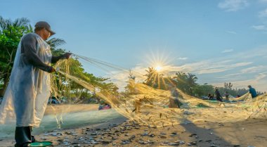 Phan Thiet, Vietnam - 30 Eylül 2018: Balıkçılar kıyı balıkçı köyü yaşayan bir şekilde yakalamak sonra balık ağı yapıyoruz. Phan Thiet, Vietnam için birçok aile ama zor iş bu