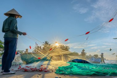 Phan Thiet, Vietnam - 30 Eylül 2018: Balıkçılar kıyı balıkçı köyü yaşayan bir şekilde yakalamak sonra balık ağı yapıyoruz. Phan Thiet, Vietnam için birçok aile ama zor iş bu
