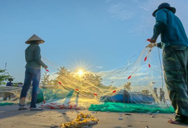 Phan Thiet, Vietnam - 30 Eylül 2018: Balıkçılar kıyı balıkçı köyü yaşayan bir şekilde yakalamak sonra balık ağı yapıyoruz. Phan Thiet, Vietnam için birçok aile ama zor iş bu