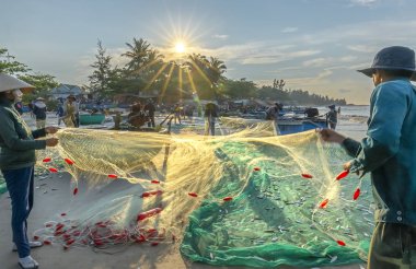 Phan Thiet, Vietnam - 30 Eylül 2018: Balıkçılar kıyı balıkçı köyü yaşayan bir şekilde yakalamak sonra balık ağı yapıyoruz. Phan Thiet, Vietnam için birçok aile ama zor iş bu