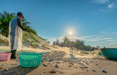 Phan Thiet, Vietnam - 30 Eylül 2018: Balıkçılar kıyı balıkçı köyü yaşayan bir şekilde yakalamak sonra balık ağı yapıyoruz. Phan Thiet, Vietnam için birçok aile ama zor iş bu
