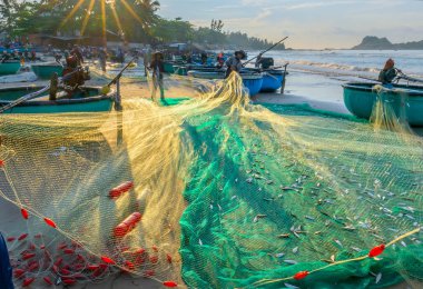 Phan Thiet, Vietnam - 30 Eylül 2018: Balıkçılar kıyı balıkçı köyü yaşayan bir şekilde yakalamak sonra balık ağı yapıyoruz. Phan Thiet, Vietnam için birçok aile ama zor iş bu