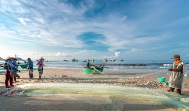 Phan Thiet, Vietnam - 30 Eylül 2018: Balıkçılar kıyı balıkçı köyü yaşayan bir şekilde yakalamak sonra balık ağı yapıyoruz. Phan Thiet, Vietnam için birçok aile ama zor iş bu