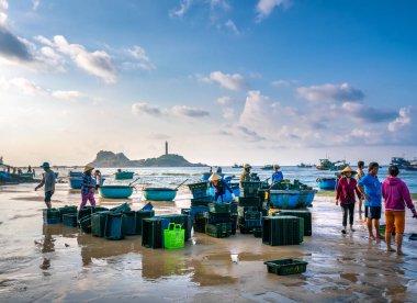 Phan Thiet, Vietnam - 30 Eylül 2018: Sepet balık satış içinde balık pazarı oturum denizler sahne kişi toplandı yorucu kürek balıkçılar balık kıyıya balıkçı köyü Phan Thiet, Vietnam getirdi