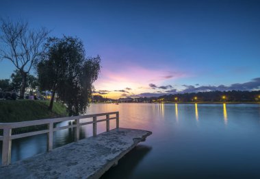 Sunrise dramatik gökyüzü ile göle bakan küçük köprüde yeni gün Vietnam turist şehir ağırlamaktadır.