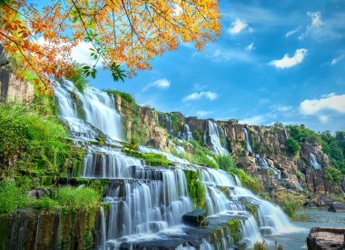 Mystical waterfall with foreground is autumn leaves in the Da Lat plateau, Vietnam. This is known as the first Southeast Asian waterfall in the wild attracted many tourists to visit clipart