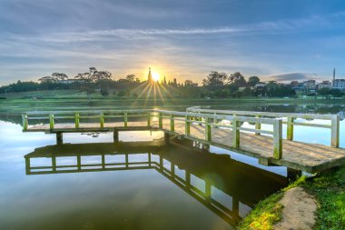 Sunrise dramatik gökyüzü ile göle bakan küçük köprüde yeni gün Vietnam turist şehir ağırlamaktadır.