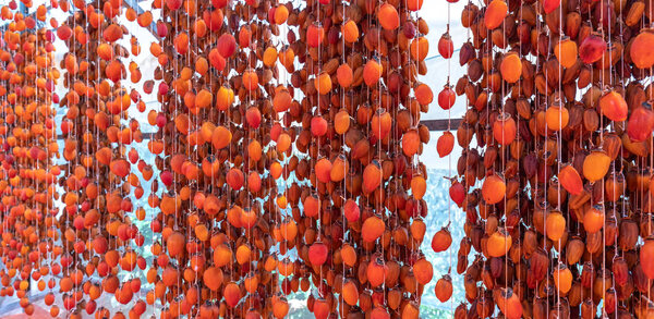 Сушеная хурма высушивается в соответствии с традиционными японскими технологиями, применяемыми в Да Лат, Вьетнам. Они висят на буровой установке в закрытом доме в течение 25 дней, чтобы произвести полный сухофруктов
