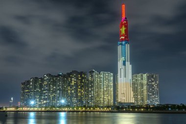 Ho Chi Minh City, Vietnam - 4 Şubat 2019: Renkli gece sahne Landmark 81 birçok parlak ışıklar hoş geldiniz delilik yeni yıl ile nehir. Dönüm noktası 81 Vietnam'da en yüksek binası olduğunu