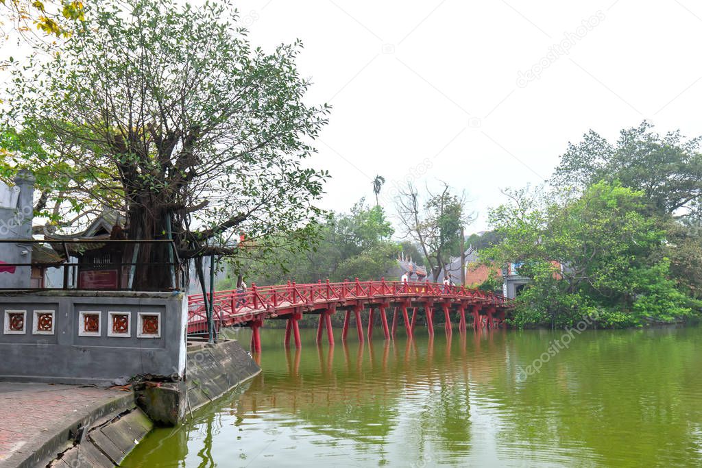 Architectural Huc Bridge looming shake trees lake with arched red crawfish culture symbolizes history thousands years in Hanoi, Vietnam