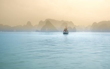 Güzel Turist yolcu gemisi Ha Long Bay kireçtaşı kayalar arasında yüzen. Burası Unesco Dünya Mirası Alanı, Kuzey Vietnam'da güzel bir doğa harikası.