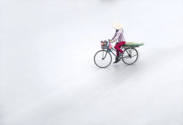 Street vendors are hurriedly cycling across the street to find customers in the small neighborhood in Hanoi, Vietnam