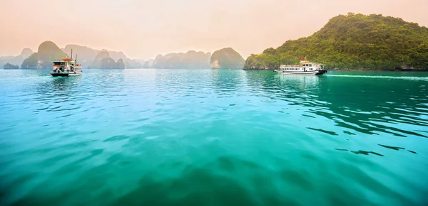 ハロン湾の石灰岩の間に浮かぶ美しい観光クルーズ船 これはユネスコの世界遺産であり ベトナム北部の美しい自然の驚異です — ストック写真