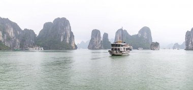 Güzel Turist yolcu gemisi Ha Long Bay kireçtaşı kayalar arasında yüzen. Burası Unesco Dünya Mirası Alanı, Kuzey Vietnam'da güzel bir doğa harikası.