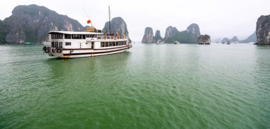 Güzel Turist yolcu gemisi Ha Long Bay kireçtaşı kayalar arasında yüzen. Burası Unesco Dünya Mirası Alanı, Kuzey Vietnam'da güzel bir doğa harikası.