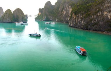 Güzel Turist yolcu gemisi Ha Long Bay kireçtaşı kayalar arasında yüzen. Burası Unesco Dünya Mirası Alanı, Kuzey Vietnam'da güzel bir doğa harikası.