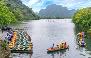 Ninh Binh, Vietnam - 5 Nisan 2019: Marinadan ayrılan turistler, Ninh Binh, Vietnam'daki Tam Coc Milli Parkı'nın nehri boyunca küçük bir tekneyle ekoturizmi ziyaret etmek için seyahat ediyor.