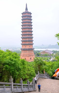 Ninh Binh, Vietnam - 5 Nisan 2019: Yabancı turistler, Vietnam'ın Ninh Binh kentinde güney doğu Asya'nın en büyüklerinden biri olan Bai Dinh pagoda'yı ziyaret etmek için merdivenlerden tırmanıyor