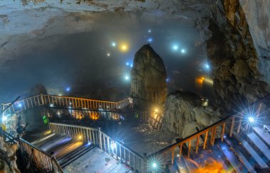 Ninh Binh, Vietnam - 7 Nisan 2019: Phong Nha milli parkında sarkıt ve dikitler ile doğal doğal koridor Paradise Cave ile ahşap geçit üzerinde turistler ziyaret, Quang Binh, Vietnam