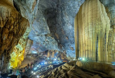 Ninh Binh, Vietnam - 7 Nisan 2019: Phong Nha milli parkında sarkıt ve dikitler ile doğal doğal koridor Paradise Cave ile ahşap geçit üzerinde turistler ziyaret, Quang Binh, Vietnam
