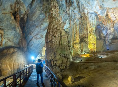 Ninh Binh, Vietnam - 7 Nisan 2019: Phong Nha Milli Parkı'nda sarkıt ve dikitlerle cennet mağarasını izleyen siluet gezgini, Quang Binh, Vietnam