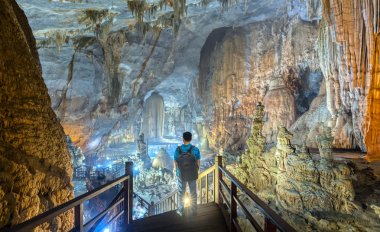 Ninh Binh, Vietnam - 7 Nisan 2019: Phong Nha Milli Parkı'nda sarkıt ve dikitlerle cennet mağarasını izleyen siluet gezgini, Quang Binh, Vietnam