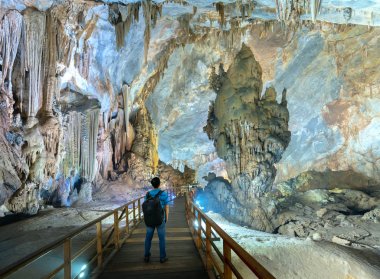 Ninh Binh, Vietnam - 7 Nisan 2019: Phong Nha Milli Parkı'nda sarkıt ve dikitlerle cennet mağarasını izleyen siluet gezgini, Quang Binh, Vietnam