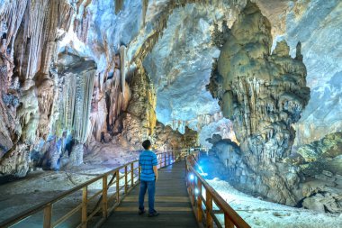 Ninh Binh, Vietnam - 7 Nisan 2019: Phong Nha Milli Parkı'nda sarkıt ve dikitlerle cennet mağarasını izleyen siluet gezgini, Quang Binh, Vietnam