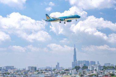 Ho Chi Minh City, Vietnam - 8 Haziran 2019: Vietnam Havayolları'na ait yolcu uçağı Airbus A321 şehir üzerinde uçan Tan Son Nhat Uluslararası Havaalanı'na inmeye hazırlanıyor, Ho Chi Minh City, Vietnam