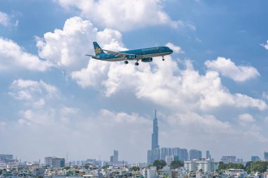 Ho Chi Minh City, Vietnam - 8 Haziran 2019: Vietnam Havayolları'na ait yolcu uçağı Airbus A321 şehir üzerinde uçan Tan Son Nhat Uluslararası Havaalanı'na inmeye hazırlanıyor, Ho Chi Minh City, Vietnam