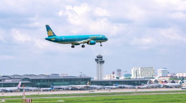 Ho Chi Minh City, Vietnam - 8 Haziran 2019: Vietnam Havayolları'na ait yolcu uçağı Airbus A321 şehir üzerinde uçan Tan Son Nhat Uluslararası Havaalanı'na inmeye hazırlanıyor, Ho Chi Minh City, Vietnam