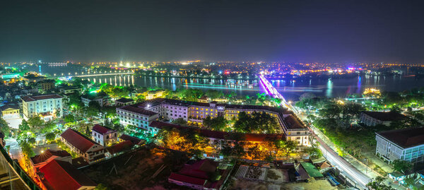 Panoramic city colorful night sparkling view from above in Hue, Vietnam.