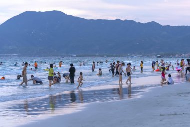 Nha Trang, Vietnam - 13 Nisan 2019: Nha Trang, Vietnam tatillerinde plaj geç saatlerde plaj keşfetmek, yüzme