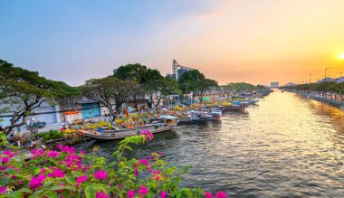 Ho Chi Minh City, Vietnam - 3 Şubat 2019: Kanal iskelesi boyunca gün batımı tekne rıhtım çiçek pazarı. Bu yer çiftçilerin Ho Chi Minh şehirde Ay Yeni Yıl kayısı ve diğer çiçekler satmak, Vietnam