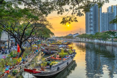 Ho Chi Minh City, Vietnam - 3 Şubat 2019: Kanal iskelesi boyunca gün batımı tekne rıhtım çiçek pazarı. Bu yer çiftçilerin Ho Chi Minh şehirde Ay Yeni Yıl kayısı ve diğer çiçekler satmak, Vietnam
