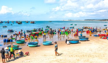 Phan Thiet, Vietnam - 19 Şubat 2019: Balık pazarı oturumu denizler, insanlar sepet balık satışı içinde toplandı, yorucu kürek balıkçıbalık Phan Thiet, Vietnam karaya balıkçı köyü getirdi